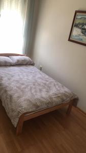 a bed sitting in a room with a window at Xenia apartments in Belgrade