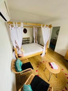 ein kleines Zimmer mit einem Bett und zwei Stühlen in der Unterkunft La VILLA MAHOT in Petite Île