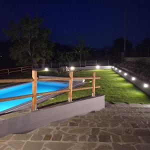 una piscina illuminata di notte con luci di Ca'Toni a Bagnone