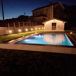 una piscina en un patio por la noche con luces en Ca'Toni en Bagnone