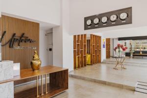 a lobby with wooden cabinets and clocks on the wall at UPTOWN Büyük Anadolu Girne Hotel in Kyrenia