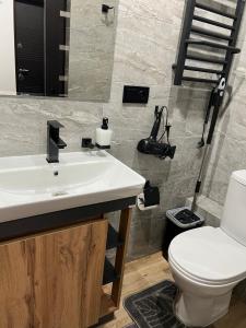 uma casa de banho com um lavatório branco e um WC. em Cozy Loft на Староєврейській 24 em Lviv