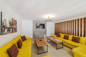 ein Wohnzimmer mit einem gelben Sofa und einem Tisch in der Unterkunft UPTOWN Büyük Anadolu Girne Hotel in Kyrenia