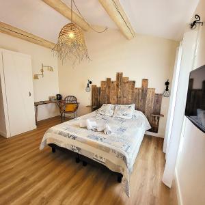 een slaapkamer met een bed en een kroonluchter bij Mas de la Paix in Montcalm