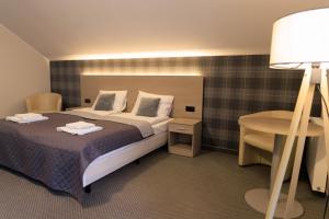 a bedroom with a bed and a table and a lamp at Pensjonat Irena in Muszyna