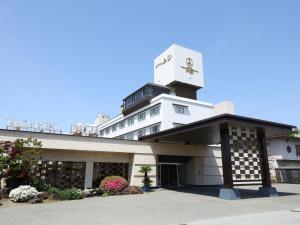 un edificio con una torre dell'orologio sopra di Hotel Fuji a Fuefuki