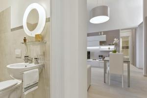 a white bathroom with a sink and a mirror at Accademia Apartment in Florence