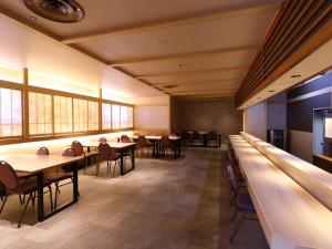 una sala da pranzo con tavoli, sedie e finestre di Hotel Fuji a Fuefuki