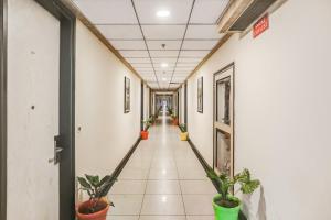 a corridor in a building with potted plants at Collection O Limewood Stay in Gurgaon