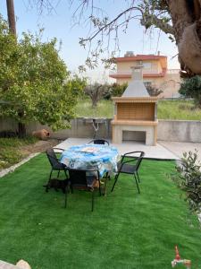 a patio with a table and chairs on a lawn at Fotis House 2 in Afantou
