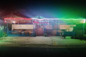 un bâtiment avec des lampes de néon allumées la nuit dans l'établissement Super OYO Riverview Resort And Restaurant, à Jhājhar