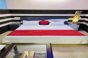 a bedroom with a large bed with a red blanket at OYO Riverview Resort And Restaurant in Jhājhar