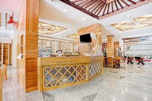 een restaurant met een bar met een bar en tafels bij Capital O 90428 Remington Hotel in Palembang