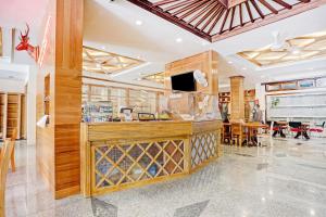 a restaurant with a bar with a counter and tables at Capital O 90428 Remington Hotel in Palembang