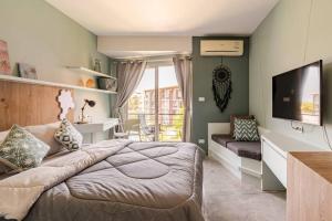 Dreamcatcher Condo/ Replay Condominium في بوفوت: غرفة نوم بسرير وتلفزيون بشاشة مسطحة