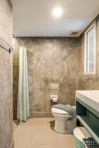 een badkamer met een toilet, een douche en een wastafel bij Dreamcatcher Condo/ Replay Condominium in Bophut 