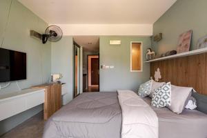 a bedroom with a bed and a flat screen tv at Dreamcatcher Condo/ Replay Condominium in Bophut 