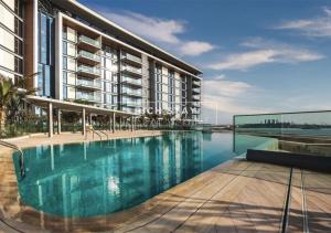 an exterior view of a building with a swimming pool at Crystal Clear 1BR Apt in Blue Waters by Rich Stay in Dubai