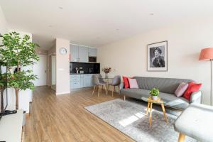 ein Wohnzimmer mit Sofa und Tisch in der Unterkunft CASA JOY Vilamoura apartment in Vilamoura