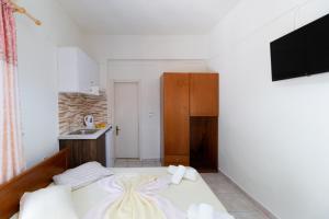 Un pequeño dormitorio con una cama y una cocina. en Nikiana Club - Studio 1, en Nikiana