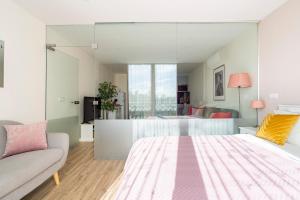 ein Schlafzimmer mit einem großen Bett und einer Couch in der Unterkunft CASA JOY Vilamoura apartment in Vilamoura