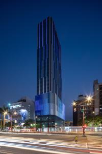 een hoog glazen gebouw in een stad 's nachts bij Solaria Nishitetsu Hotel Taipei Ximen in Taipei
