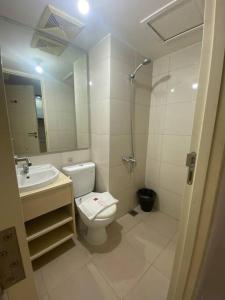 ein Bad mit einem WC, einem Waschbecken und einer Dusche in der Unterkunft Alexa at Tanglin Apartemen in Surabaya