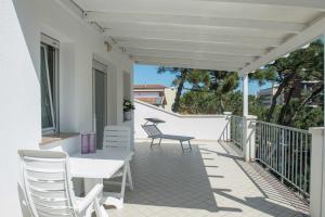 eine Terrasse mit einem Tisch und Stühlen auf dem Balkon in der Unterkunft Residence Ola in Milano Marittima