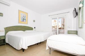 2 Betten in einem Zimmer mit weißen Wänden in der Unterkunft Hostal Manolo in Garrucha