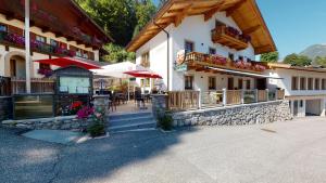 un edificio con un restaurante con mesas y sillas en Forellenstube, en Lofer