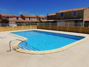 una gran piscina en un patio con casas en Villa Gruissan, 2 pièces, 6 personnes - FR-1-409A-6, en Gruissan
