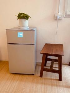 a plant on top of a refrigerator next to a table at Always Boutique Stay in Pai