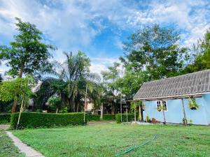 a yard with a blue house with a hose at Always Boutique Stay in Pai +11 photos