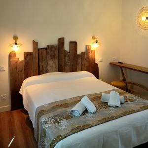 een slaapkamer met een groot bed en 2 handdoeken bij MANADE SAINT LOUIS Mas de La Paix in Montcalm