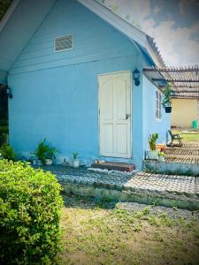 una casa azul con una puerta blanca y algunas plantas en Pai Casita, en Pai