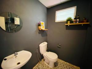 a bathroom with a white toilet and a sink at Pai Casita in Pai