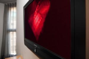 a television with a red light on the screen at Onix Liceo in Barcelona
