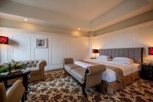 a large bedroom with a large bed and a couch at Crown Garden Hotel in Kota Bharu