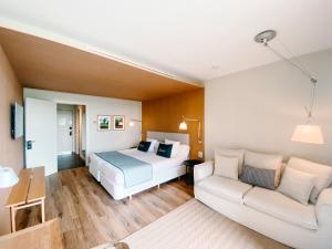 a hotel room with a bed and a couch at Empordà Golf Resort in Torroella de Montgrí