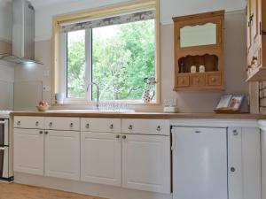 a kitchen with white cabinets and a window at Bella Vista in Ryde