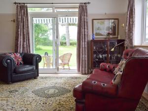a living room with two leather chairs and a sliding glass door at Bella Vista in Ryde
