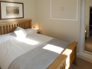 a bedroom with a large bed with white sheets at The Old Clockmakers in Pateley Bridge