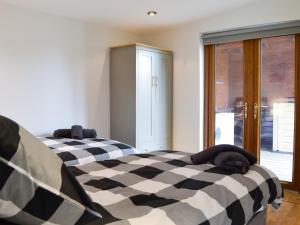 Great Orton的住宿－Kimberdale Lodge，一间卧室配有两张带黑白床单的床