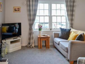 sala de estar con sofá y TV en Nice Cottage In Gatehouse Of Fleet With 2 Bedrooms And Wifi en Gatehouse of Fleet