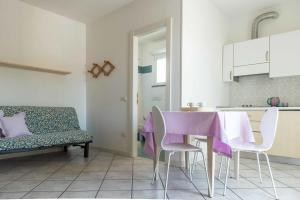 a kitchen with a table and chairs and a couch at Residence Ola in Milano Marittima