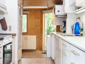 cocina con electrodomésticos blancos y paredes de madera en 5 person holiday home in Odder, en Odder