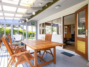 una mesa de madera y sillas en un porche en 5 person holiday home in Odder, en Odder