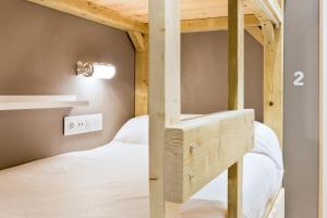 a bedroom with two bunk beds and a light on the wall at Ant Hostel Barcelona in Barcelona
