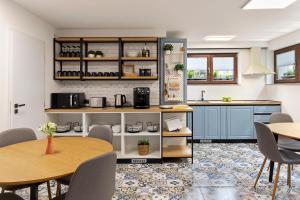 una cocina con armarios azules, mesas y sillas en 6Rooms, en Sibiu