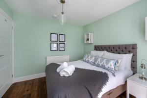 a bedroom with a large bed with a gray headboard at Sea View 4 Bedroom Property in Mumbles in The Mumbles